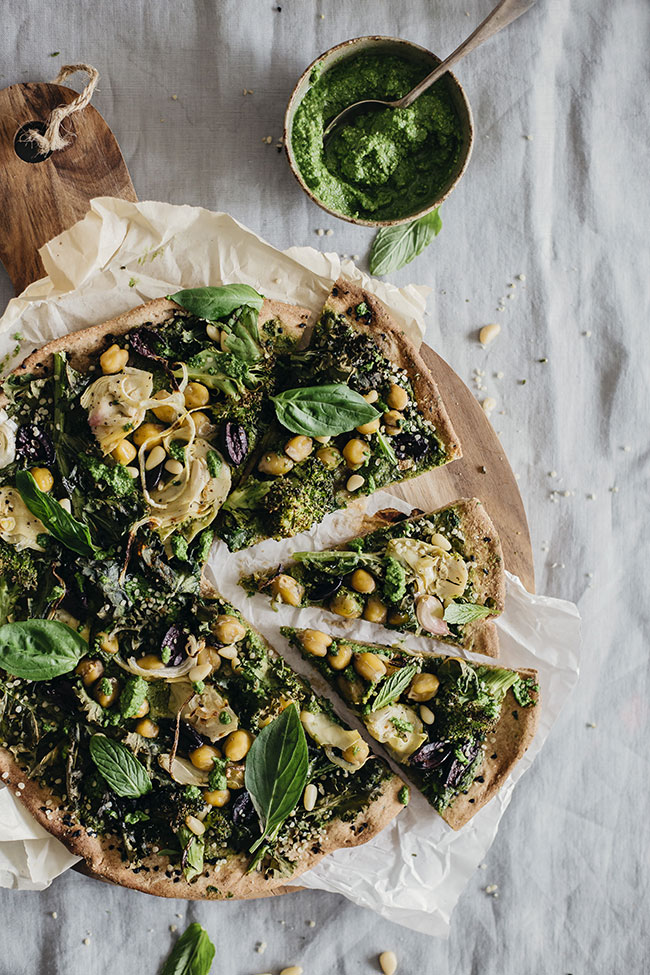 Green Pizza with flatbread crust, kale pesto, artichokes, kalamata olives and aromatic herbs #vegan | TheAwesomeGreen.com