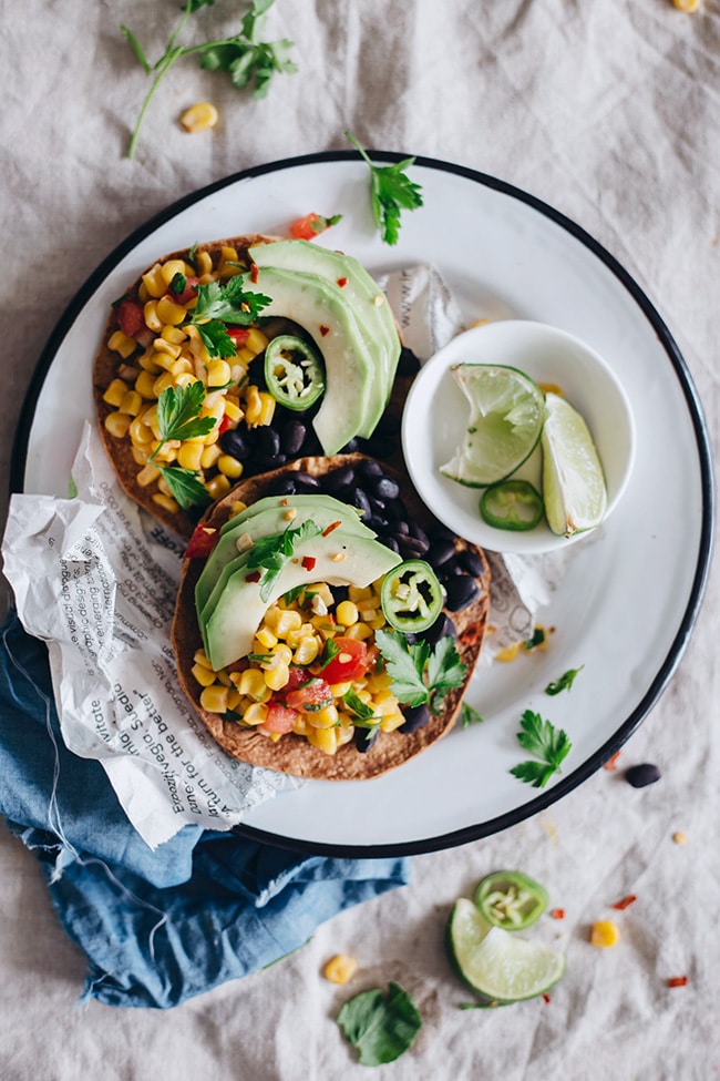 Crispy tostadas with spicy black beans, sweet corn salsa and avocado slices #summer #vegan | TheAwesomeGreen.com