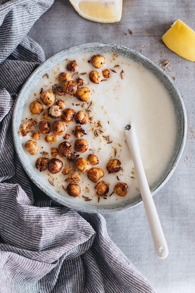 Easy and super creamy cauliflower soup with tahini, garnished with mustard roasted chickpeas #vegan | TheAwesomeGreen.com