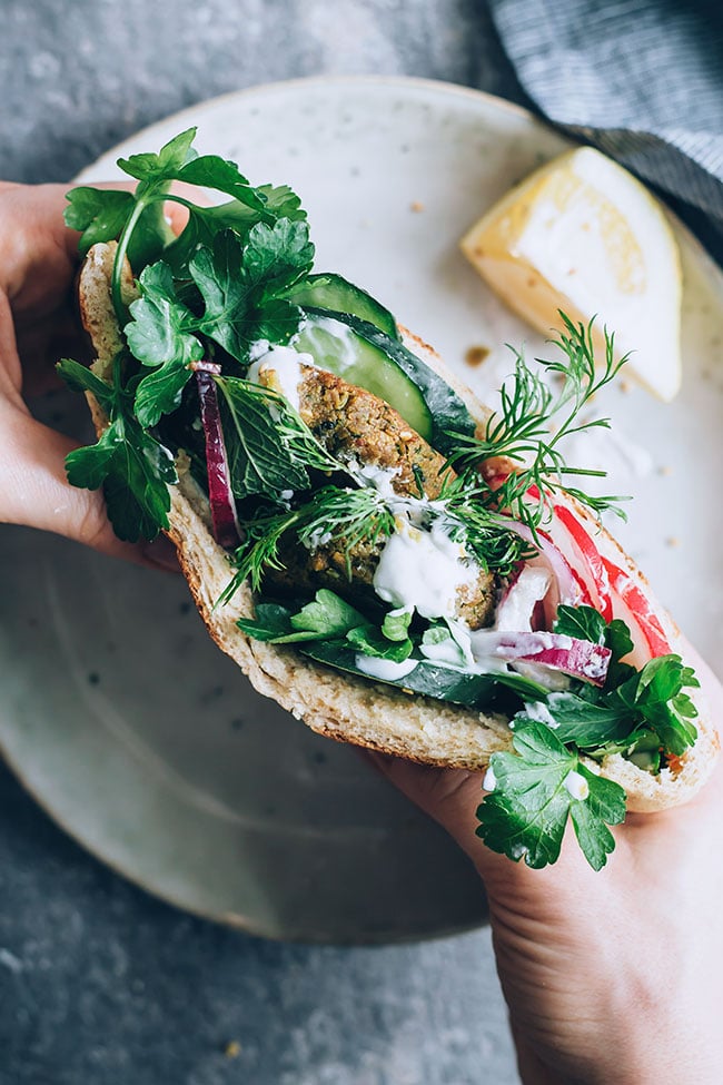 Fresh greens loaded falafel sandwich with lemon tahini sauce #vegetarian #falafel #chickpeas #sandwich #lunch | TheAwesomeGreen.com